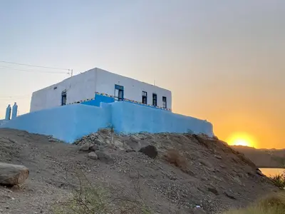 a building on a hill with the sunset in the background at Per Ankh - Heissa island - Aswan in Aswan