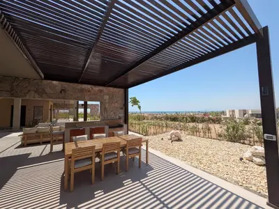 a patio with a wooden table and chairs under awning at Spacious 3BR Apartment Glorious Panoramic Seaviews in Hurghada