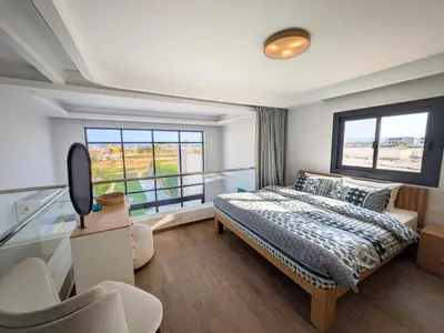 a bedroom with a bed and a large window at Beautiful 2BR Mesca Beach Front Loft in Soma bay in Hurghada