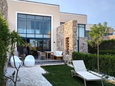 a home with a patio with a table and chairs at Beautiful 2BR Mesca Beach Front Loft in Soma bay in Hurghada