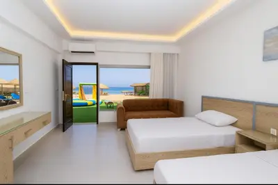 a bedroom with two beds and a view of the beach at Aquatic Village - Red Sea Resort in Hurghada