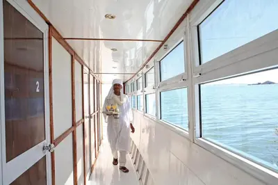 a man in white walking on a boat at Nubiana Boat