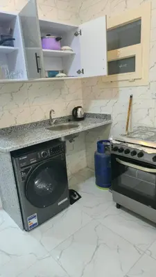 a kitchen with a dishwasher and a sink and a stove at عمارة الرومانى in Hurghada