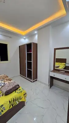 a bedroom with a bed and a mirror and a desk at عمارة الرومانى in Hurghada
