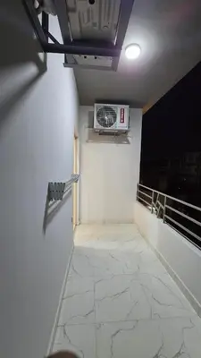 a room with a balcony with a microwave on the wall at عمارة الرومانى in Hurghada