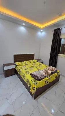 a bedroom with a bed with a yellow blanket at عمارة الرومانى in Hurghada