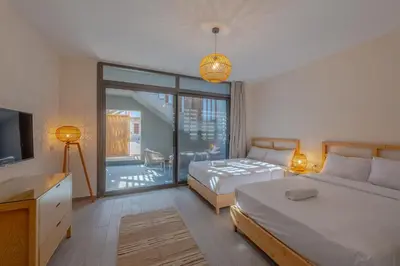a bedroom with two beds and a television and a balcony at Dreamy Studio in Bali Compound, El Gouna in Hurghada