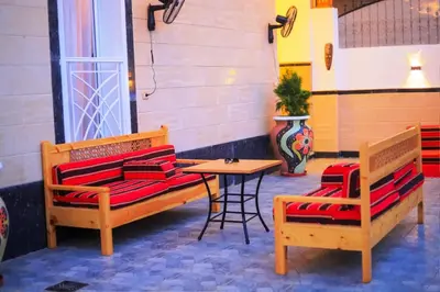 a patio with two benches and a table and a vase at Hamed's House Luxor in Luxor
