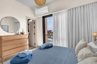 a bedroom with a large bed and a mirror at Bright & Elegant 2BR Retreat - Kamaran El Gouna in Hurghada