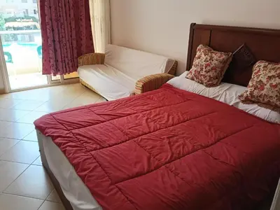 a bedroom with a red bed and a chair at فلورانزا خمسين f012 in Hurghada