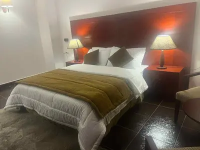 a bedroom with a large bed and two lamps at Grand Cleopatra Hotel-Luxor in Luxor