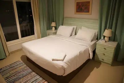 a bedroom with a large white bed and a window at Stunning 4BD Apartment Lagoon View-Gouna in Hurghada