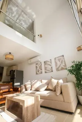 a living room with a couch and a table at Modern Sahl Hasheesh Pool Duplex - Beach & Wi-Fi in Hurghada