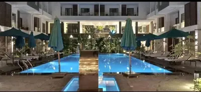 a large swimming pool with umbrellas in a building at 412atthepavilionimperialHurghada in Hurghada