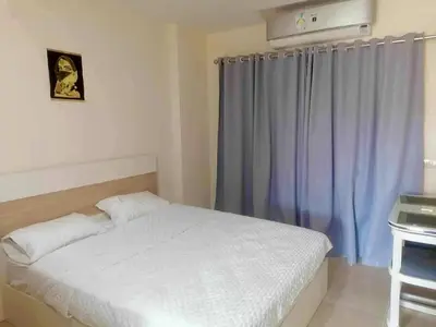 a bedroom with a white bed and a blue curtain at Pearl of Tiba Golden Resort in Hurghada