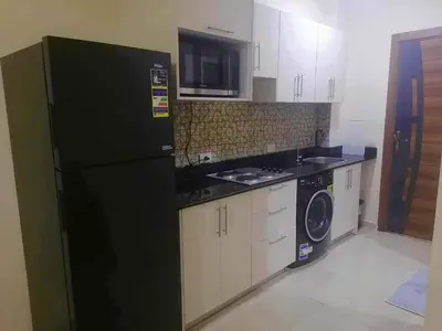 a kitchen with a black refrigerator and a microwave at Pearl of Tiba Golden Resort in Hurghada