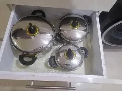 a stove top with four pots and pans in a drawer at Pearl of Tiba Golden Resort in Hurghada