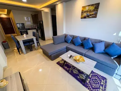 a living room with a blue couch and a table at Amazing View! Beach Access & Pool Hurghada in Hurghada