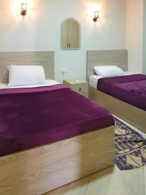 two beds in a hotel room with purple sheets at Amazing View! Beach Access & Pool Hurghada in Hurghada