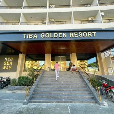 a man walking down the stairs in front of a building at Tiba Golden Resort Hurghada in Hurghada