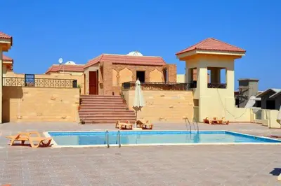a swimming pool in front of a house at 310 el Andalous Apartment in Hurghada