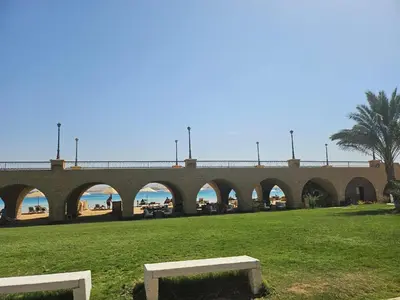 a bridge over a field with a beach in the background at 310 el Andalous Apartment in Hurghada