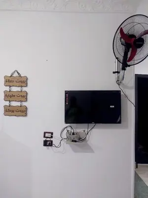 a white wall with a television and a fan at Economy Onebedroom Apartment Hurghada in Hurghada