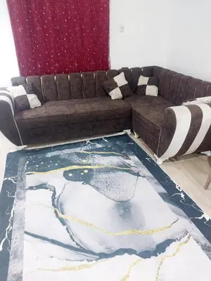 a living room with a brown couch and a rug at Economy Onebedroom Apartment Hurghada in Hurghada