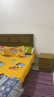 a bedroom with a bed and a nightstand next to it at الغردقة - القيادات - بالقرب من سيتي سنتر مول و شاطئ الجيش in Hurghada