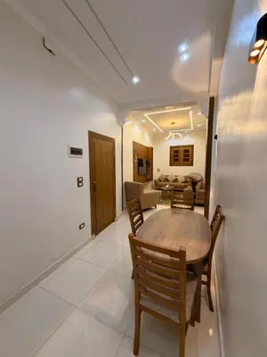 a dining room and living room with a table and chairs at Omar Apartment in Luxor