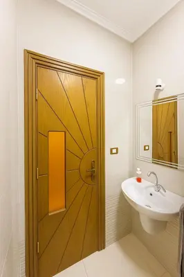 a bathroom with a wooden door next to a sink at Omar Apartment in Luxor