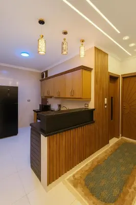 a kitchen with wooden cabinets and a black counter top at Omar Apartment in Luxor