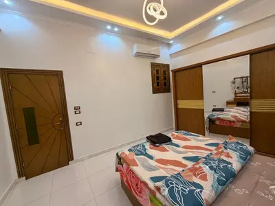 a bedroom with a bed and a door to a room at Omar Apartment in Luxor