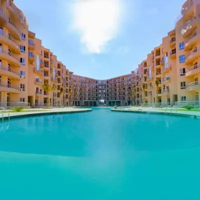 a large swimming pool in front of a large apartment building at كومباوند البرنسيسه in Hurghada