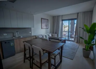 a kitchen and dining room with a wooden table and chairs at Ancient Sands El Gouna Hurghada in Hurghada