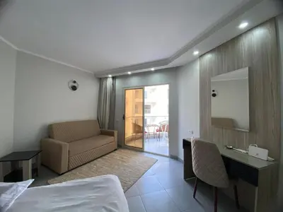 a hotel room with a bed and a couch and a mirror at One bedroom Chalet Scandic Resort Hurghada in Hurghada