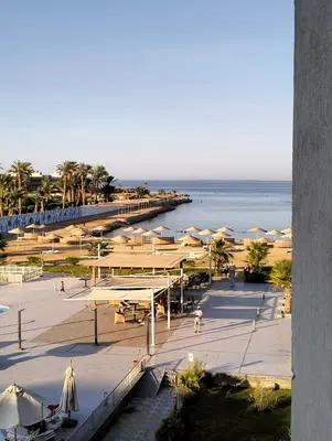 a view of a beach with umbrellas and the ocean at One bedroom Chalet Scandic Resort Hurghada in Hurghada