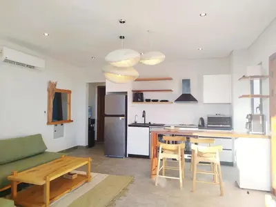 a kitchen with a couch and a table with chairs at Luxury 1 BR apartment with garden, Mesca - Somabay in Hurghada