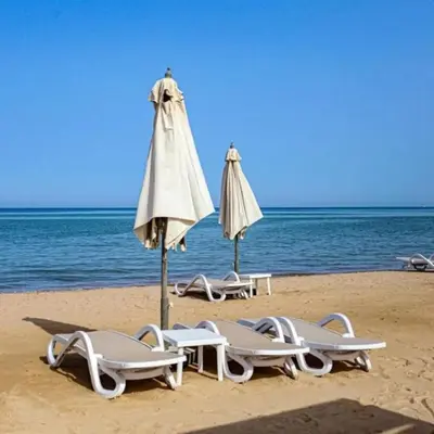 a group of umbrellas and lounge chairs on a beach at Mangrove M1-5B-13 in Banī Ghālib