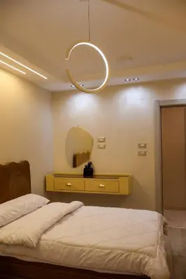 a bedroom with a bed and a mirror at Cozy Luxe Apartment in Central Aswan in Aswan