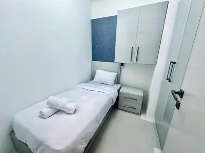 a small room with a bed and a cabinet at Comfortable 3BR Apartment in Swan Lake I El Gouna Ground Floor, Garden, Terrace & Lagoon Access in Hurghada