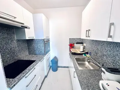 a kitchen with white cabinets and a sink at Comfortable 3BR Apartment in Swan Lake I El Gouna Ground Floor, Garden, Terrace & Lagoon Access in Hurghada
