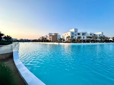 a large swimming pool with buildings in the background at Comfortable 3BR Apartment in Swan Lake I El Gouna Ground Floor, Garden, Terrace & Lagoon Access in Hurghada
