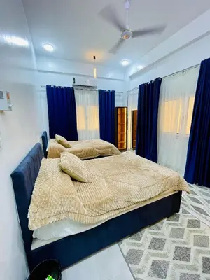 a bedroom with two beds and blue curtains at Quiet Villa in Luxor