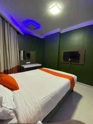 a bedroom with a large bed in a room with green walls at Nile Plaza Suites in Aswan