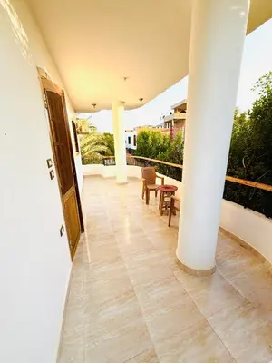 a porch with a white pillar and a table and chairs at Luxor Old nile apartment in Luxor