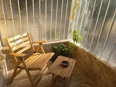 a chair and a table in front of a window at Karima house B in Al Aqālitah