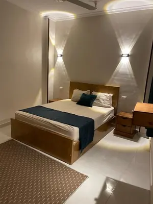 a bedroom with a bed and a table and lights at Luxe Nest Luxor Serviced Apartments 301 in Luxor