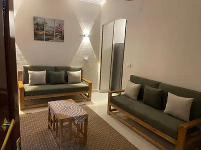 a living room with two green couches and a table at Luxe Nest Luxor Serviced Apartments 301 in Luxor