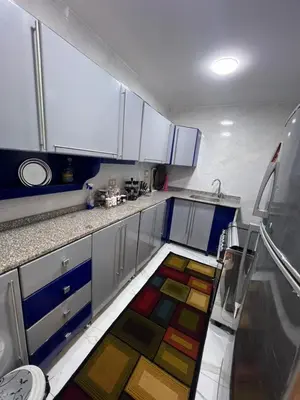 a kitchen with a colorful rug on the floor at Aswan in Nag` el-Ramla